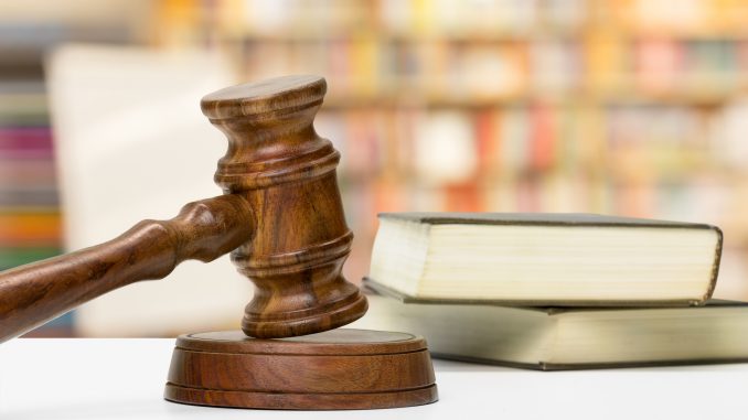 Wooden gavel and books on wooden table